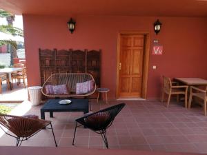 コラレホにあるAppartamento Spagnolo Oasis Tamarindoのパティオ(椅子、テーブル、ドア付)