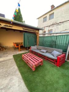 a patio with a red bench and a table at Haraplak in Hajdúszoboszló