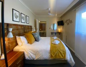 a bedroom with a large bed with a wooden headboard at Dolphin Circle Bed and Breakfast in Plettenberg Bay