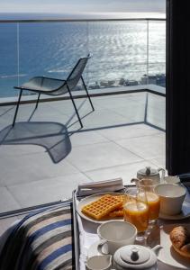 a table with a tray of breakfast food on a balcony at ONLY Boutique Suites & Residences in Limassol