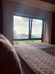 um quarto com uma cama e uma grande janela em Private Spa Lodge Odenwald em Lindenfels
