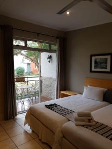 um quarto com uma cama e vista para um pátio em Villa Paradiso em Hartbeespoort
