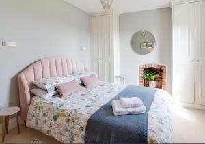 a bedroom with a bed with pillows and a fireplace at Honey Cottage in Richmond