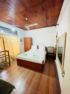 um quarto com uma cama e um tecto de madeira em Mangala Lodge em Kurunegala