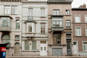 um edifício de tijolo alto com portas e janelas brancas em RODELIJV em Gent