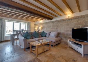 a living room with a couch and a tv at Holly Tree Cottage in Aislaby