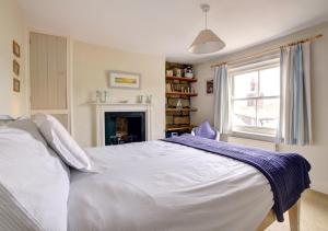 a bedroom with a white bed and a fireplace at Holmlea in Robin Hood's Bay