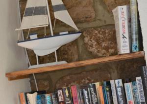 a book shelf with a model boat on it at Holmlea in Robin Hood's Bay