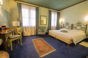 Habitación de hotel con cama, escritorio y cama sidx sidx en Hotel Boccaccio, en Calcinaia