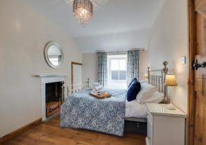 a bedroom with a bed and a fireplace at Holly Tree Cottage in Aislaby