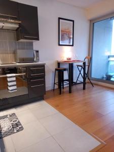 a kitchen with a stove and a table in it at Superbe STUDIO (28m2) avec terrasse / vue TOUR EIFFEL / PUTEAUX in Puteaux