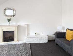 a living room with a couch and a fireplace at Campbeltown Loch in Campbeltown