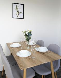 una mesa de madera con platos y copas de vino. en Campbeltown Loch, en Campbeltown