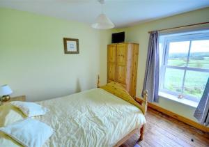 a bedroom with a bed and a large window at Hole In The Ellers in Lealholm