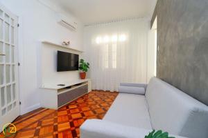 een woonkamer met een bank en een tv bij Adorável 2 quartos em predio ART-DECOR in Rio de Janeiro
