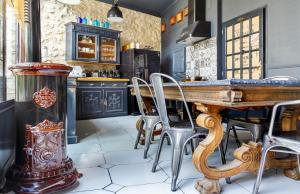a kitchen with a wooden table and chairs at Le 215 Gambetta boutique hôtel en Provence in Cavaillon