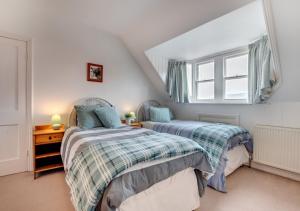 two beds in a attic bedroom with a window at Holbrooks House in Robin Hood's Bay