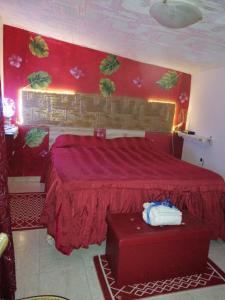1 dormitorio con cama roja y pared roja en CASA VACANZE ROSA BLU, en Giffoni Valle Piana