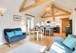 a living room with a table and chairs and a kitchen at Hog Barn at Howe End in Castleton