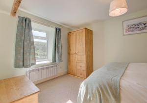 a bedroom with a bed and a window at Hillyard in Hawes