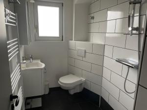 uma casa de banho com um WC, um lavatório e uma janela em Petras Ferienwohnung em Villingen-Schwenningen