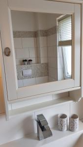 a bathroom with a mirror above a sink at Familienwohnung MANDO in Neue Tiefe Fehmarn