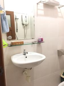 a white sink in a bathroom with a mirror at Thanhha Guesthouse in Ho Chi Minh City