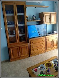 uma sala de estar com televisão e um centro de entretenimento em madeira em Apartamento Solaes Climatizado em Benicarló