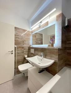 a bathroom with a sink and a toilet and a mirror at REGENCY Apartments - Stylische zentrale 50m2 Wohnung mit Balkon, Wasserblick und Netflix in Hannover