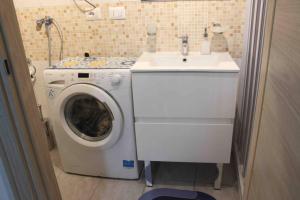 uma máquina de lavar roupa e um lavatório na casa de banho em Chez Elle - Casa vacanze zona centro em Catânia