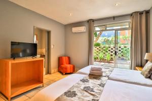a bedroom with a bed and a flat screen tv at Villa Paradiso in Hartbeespoort