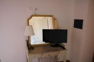 einen Fernseher auf einem Schreibtisch vor einem Spiegel in der Unterkunft Roba Albanisi in Aragona