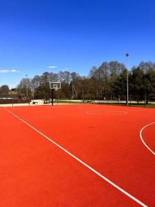 un campo da tennis arancione con canestro da basket di Amazing Riverside home/Kayaks&Sauna/Grill&Garden a Pabradė