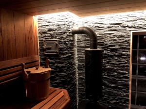 bagno con lavandino e parete in pietra di Amazing Riverside home/Kayaks&Sauna/Grill&Garden a Pabradė