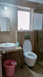 a bathroom with a toilet and a sink and a shower at P N A Apartments - Manpada in Thane