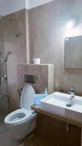 a bathroom with a toilet and a sink and a shower at P N A Apartments - Manpada in Thane