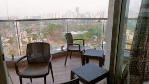 balcón con sillas y vistas a la ciudad en P N A Apartments - Manpada, en Thane