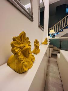two yellow sculptures sitting on a white counter in a room at Matogianni Hotel in Mikonos