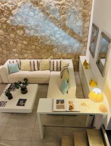 a living room with a couch and a stone wall at Matogianni Hotel in Mýkonos City