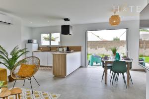 uma cozinha e sala de jantar com mesa e cadeiras em Maison neuve - La Marinière - classée 4 étoiles - emplacement idéal em Les Sables-dʼOlonne