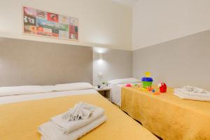 a bedroom with two beds with towels on them at Hotel Reyt in Rimini