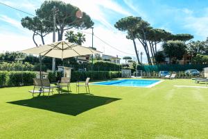 a patio with an umbrella and chairs and a pool at Residence San Francesco in Tirrenia
