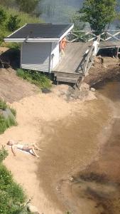 a person laying on the sand in front of a house at Évika boutique hotel in Eskilsby