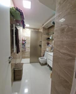 ein Bad mit einer Dusche, einem WC und einem Waschbecken in der Unterkunft Tree cane apartman in Budva