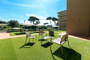 a group of chairs and tables on a lawn at Residence San Francesco in Tirrenia