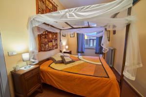 a bedroom with an orange bed with a canopy at Alloggio Turistico Centro Storico Malatesta in Montefiascone +25 photos