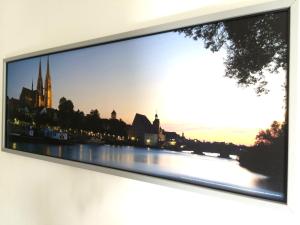 een televisie aan een muur met een foto van een rivier bij Apartment Sunshine in Regensburg