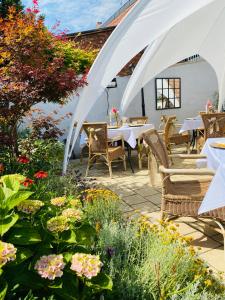 - une terrasse avec une table, des chaises et des fleurs dans l'établissement Boutique Hotel ma maison, à Dömitz