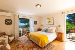 a bedroom with a bed and a large window at Villa Le Port d'attache in Vallauris