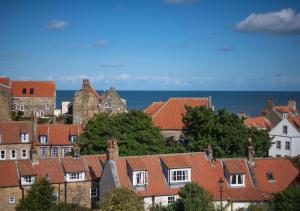 a group of houses with the ocean in the background at Hillside in Robin Hood's Bay
